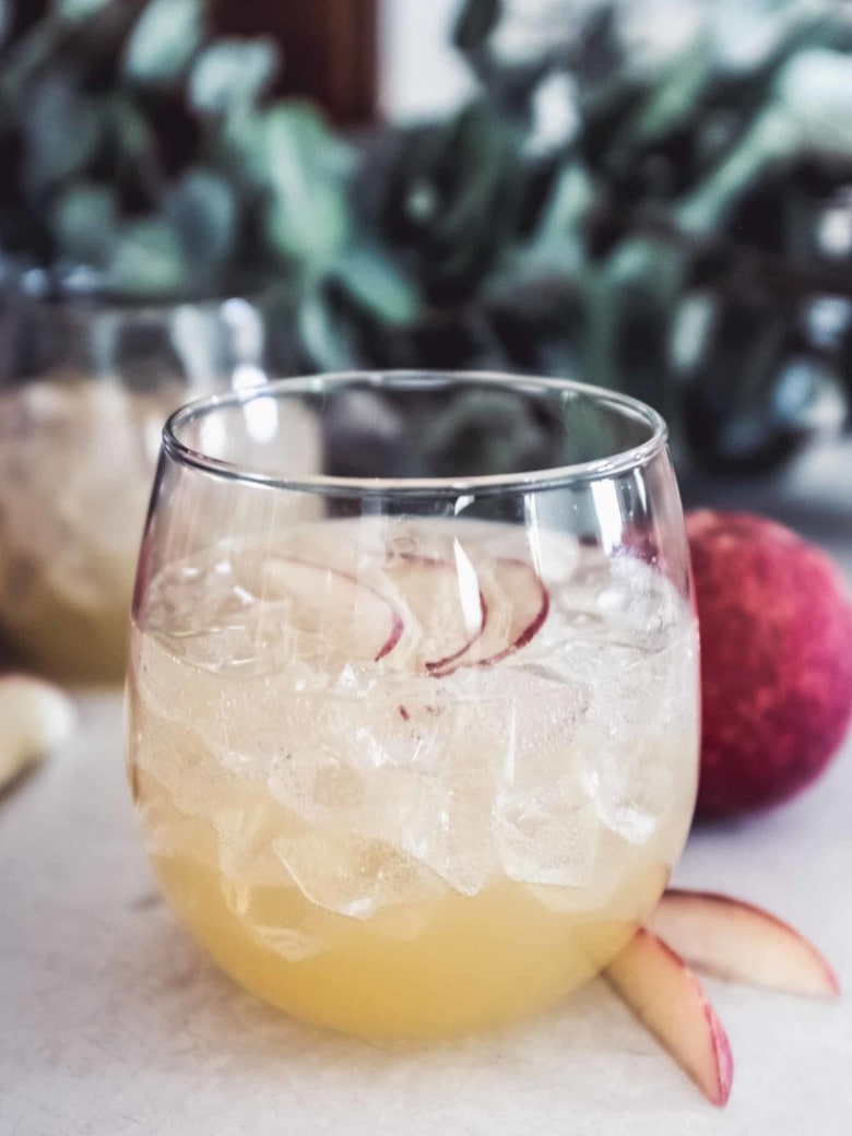 коктейль с персиком и ромашкой в бокале со льдом